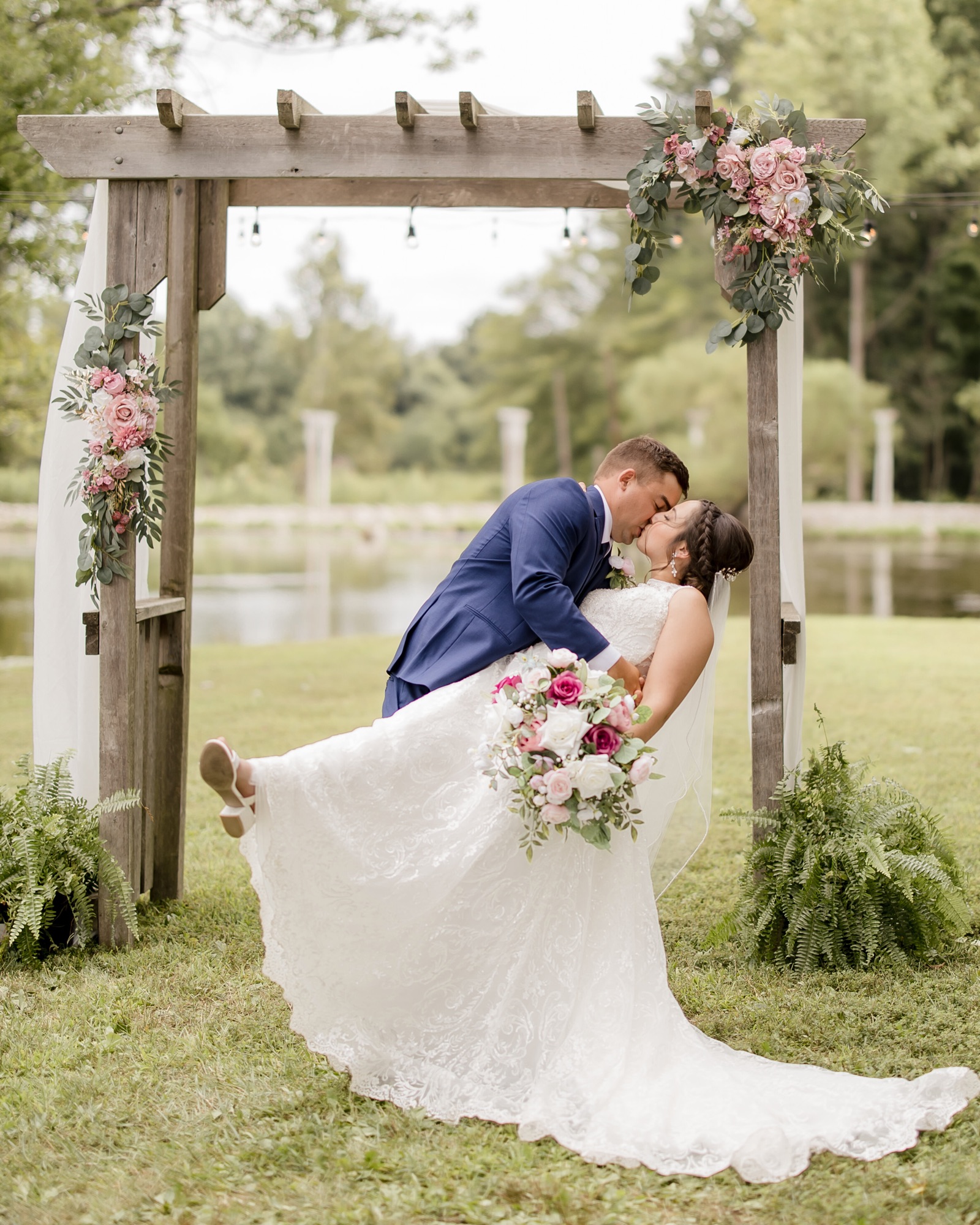 Jarrett and Naomi under the ceremony arbor by the pond at Abram Farms