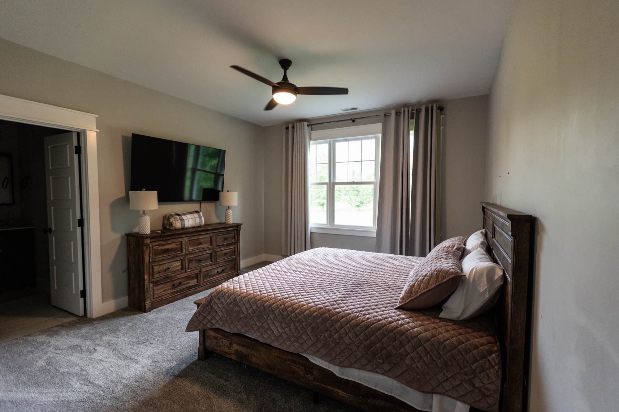Bedroom at Lakeside Manor with mounted TV and dresser
