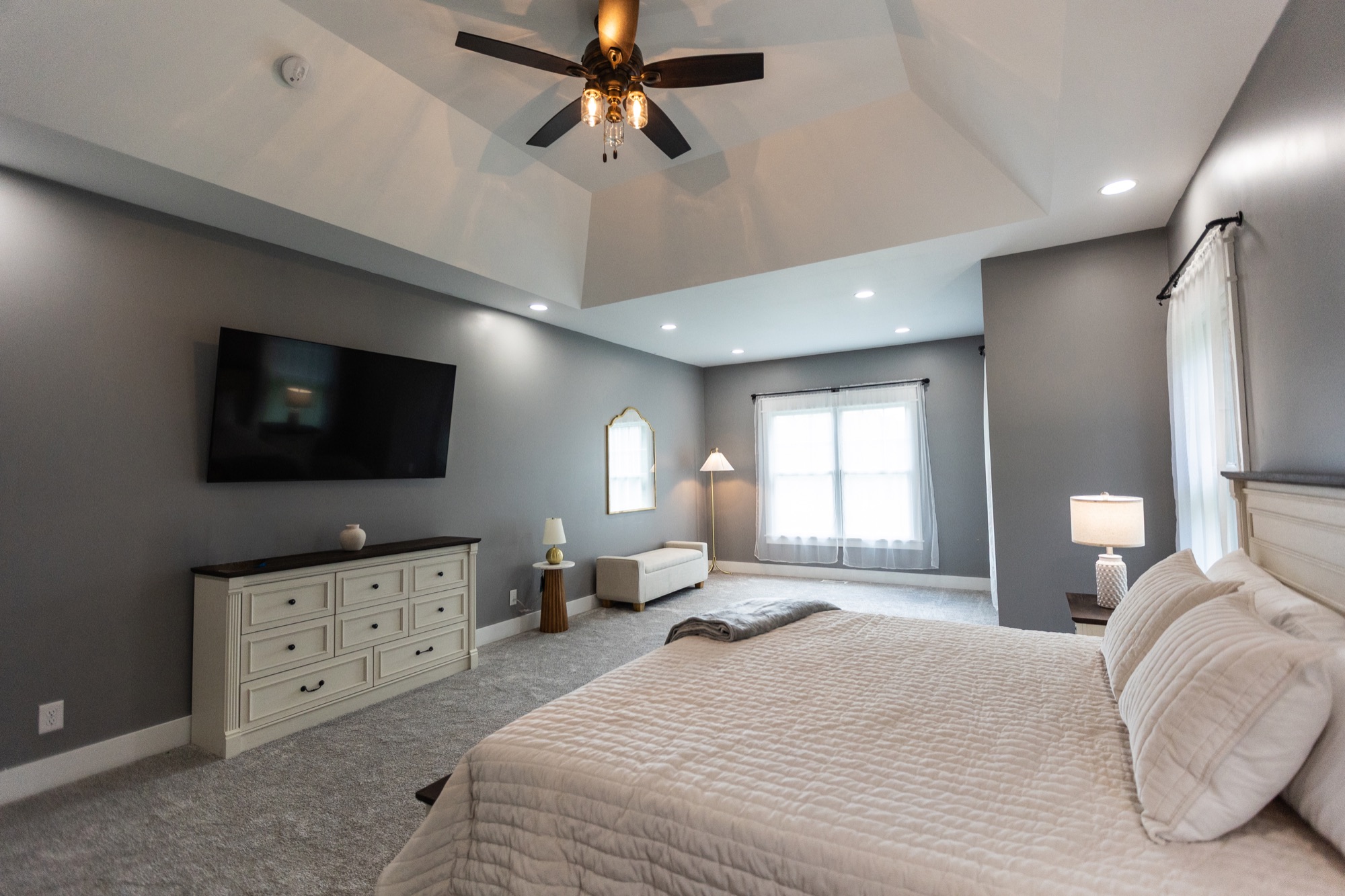 Primary bedroom at Lakeside Manor with a tray ceiling and sitting area