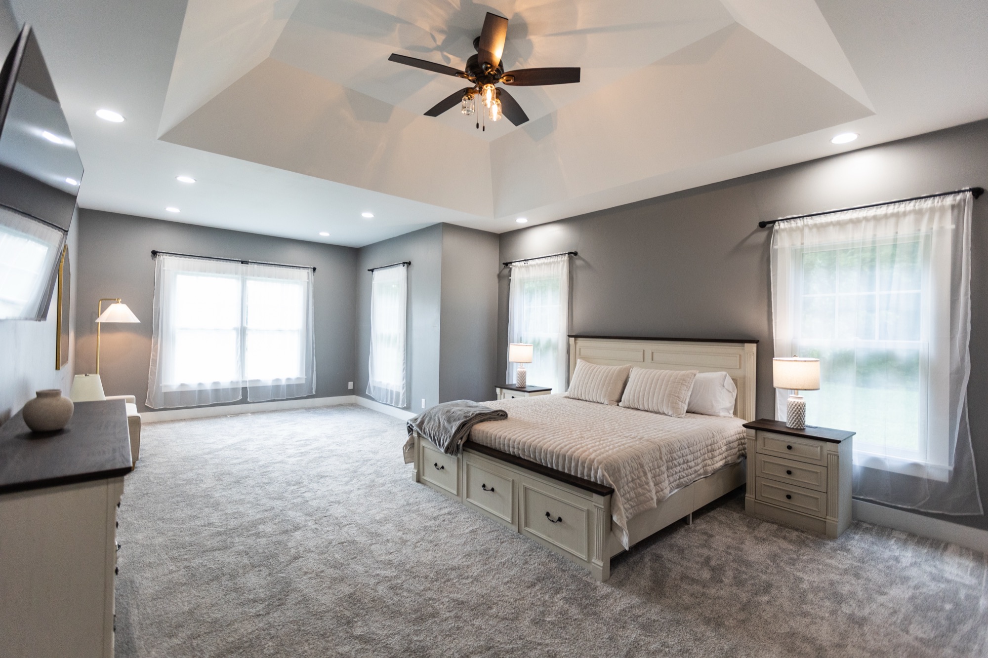 Bedroom at Lakeside Manor with a tray ceiling and multiple windows